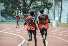 Dois atletas correm lado a lado em uma pista de atletismo em Nairobi, no Quênia.