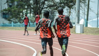 Dois atletas correm lado a lado em uma pista de atletismo em Nairobi, no Quênia.