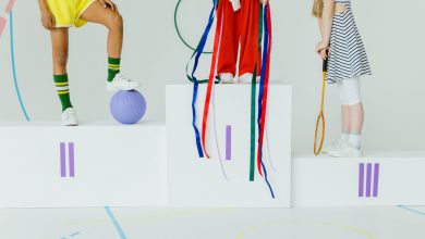Crianças em um pódio esportivo, ao lado de equipamentos de competição, em um ambiente recreativo.