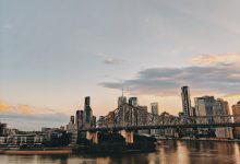 Vista do skyline de Brisbane ao entardecer, com a Story Bridge sobre o rio Brisbane.