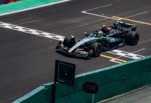 Carro de Fórmula 1 cruza a linha de chegada em um circuito durante uma corrida diurna