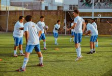 Jovens jogadores de futebol participam de exercícios de treinamento em um campo ao ar livre.