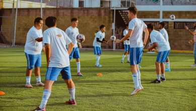 Jovens jogadores de futebol participam de exercícios de treinamento em um campo ao ar livre.